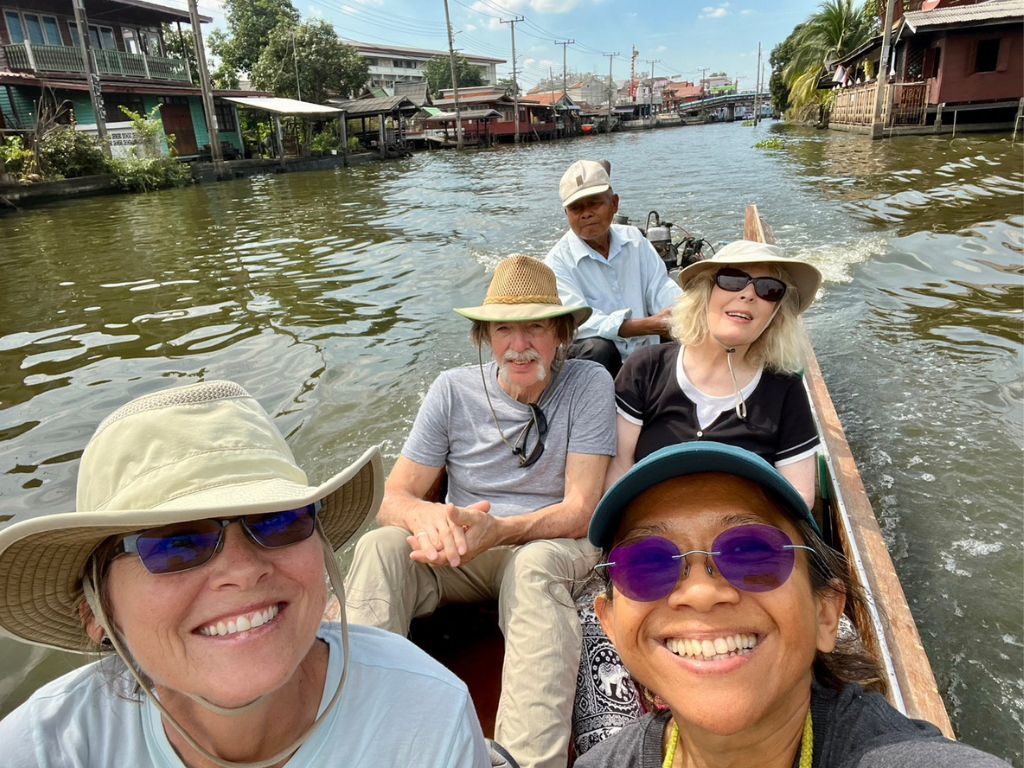 Cycling alongside historic Bangkok canals with traditional wooden houses and boats