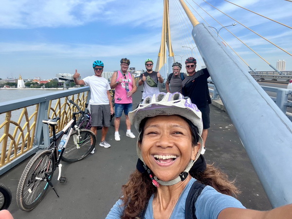 Happy tour guide taking a selfie with the cycling group on the iconic Rama 8 bridge