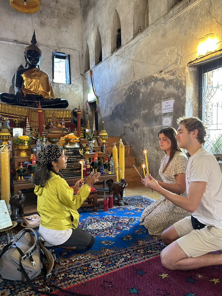 Guests lighting candles and praying inside the historic abandoned temple from the 1700s