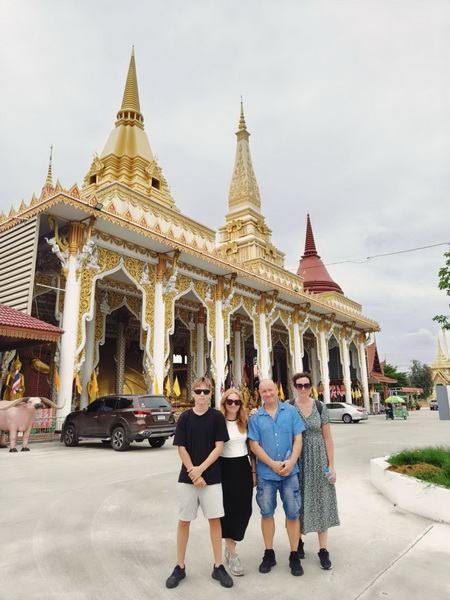 Tour group posing in front of a stunning golden temple in Nonthaburi