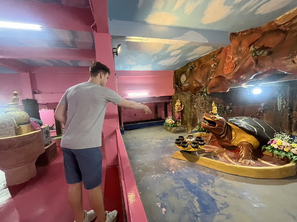 Visitor exploring the unique and colorful interior of a temple with outlandish statues