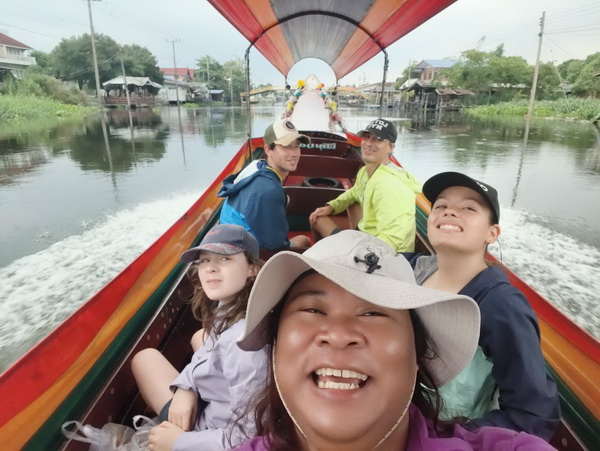 Tour group enjoying a selfie on a long tail boat cruising through Bangkok canals