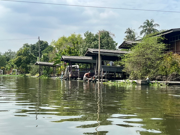 Peaceful rural canal scene with a man working by the water's edge