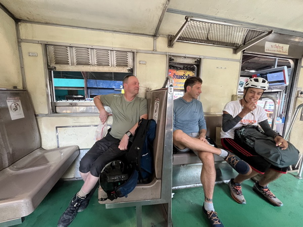 Cyclists relaxing on the local Thai train with their bikes during the journey south-west