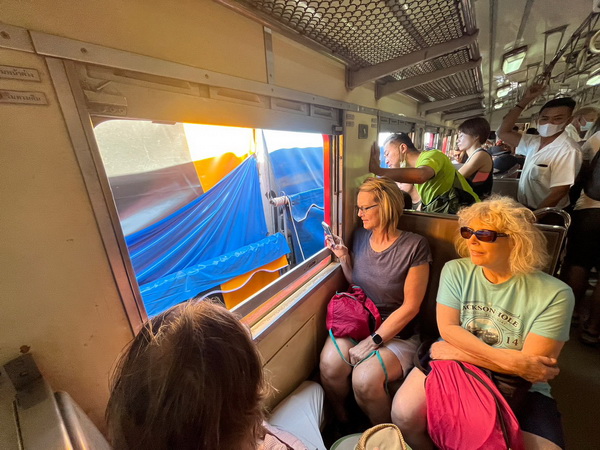 Guests enjoying the scenic local train journey back through Thai countryside