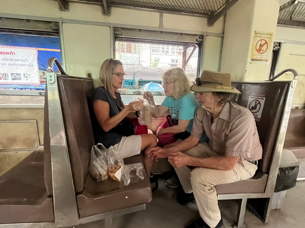 Guests sharing snacks and stories on the local train during the Crazy Markets tour