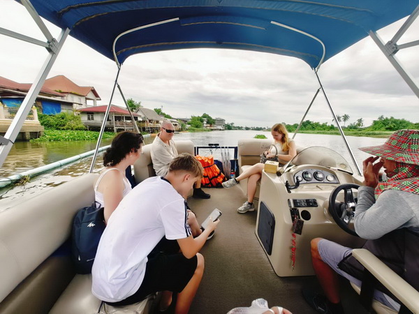 Family enjoying a scenic boat ride to lunch on the Nakhon Pathom cycling tour