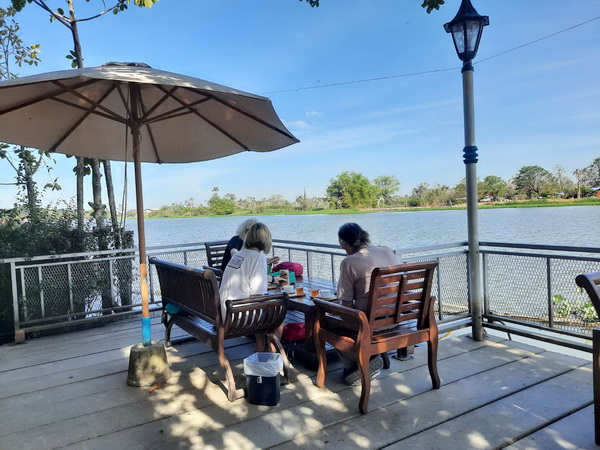 Guests enjoying a coffee break with river views at the Woodlands cafe in Nakhon Pathom