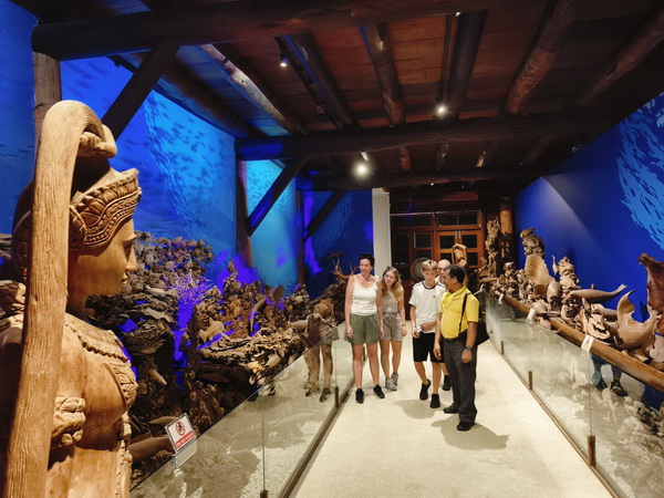 Tourists admiring exquisite wood carvings at the Woodlands museum in Nakhon Pathom