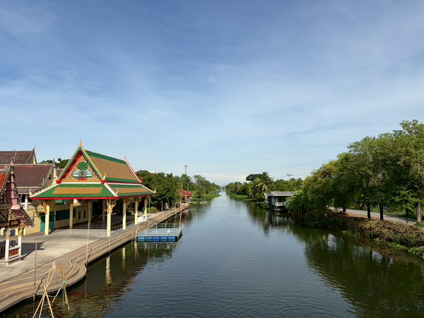Peaceful scenic view of the Ta Chin river with traditional Thai pavilions along the bank
