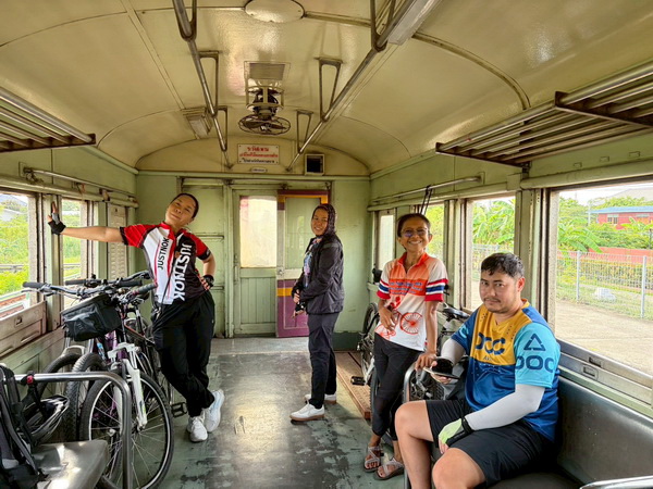 Tour group with their bicycles inside the local train carriage heading to Nakhon Pathom