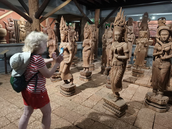 Visitor photographing beautiful traditional Thai dancer wood carvings at the Woodlands museum