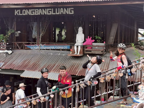 Cyclists posing at the artistic Klong Bang Luang cafe in the canal-side artist village