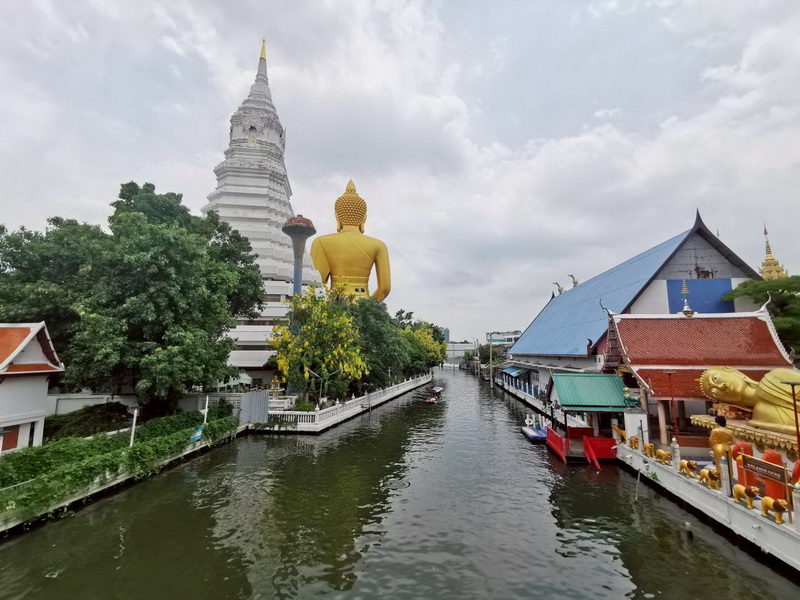 Canal view of Wat Paknam Phasi Charoen with golden Buddha and white chedi