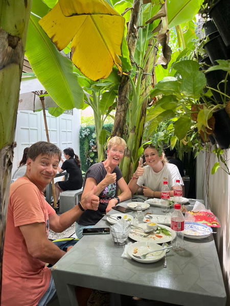 Tour guests enjoying a delicious lunch surrounded by tropical plants at the artist village