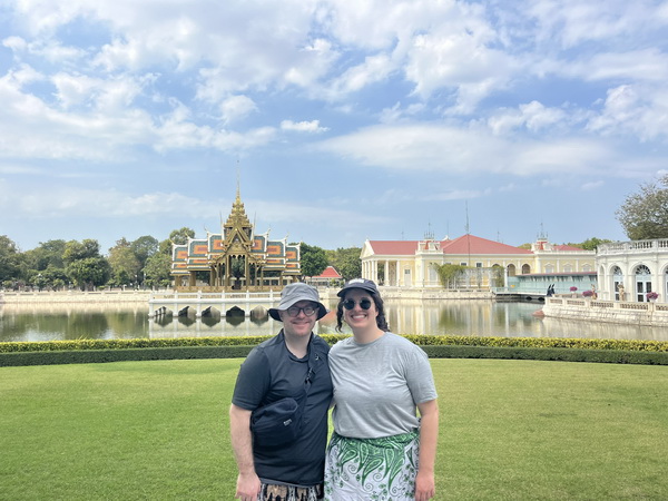 Guests posing at Bang Pa In Summer Palace with ornate Thai pavilion and European architecture across the lake