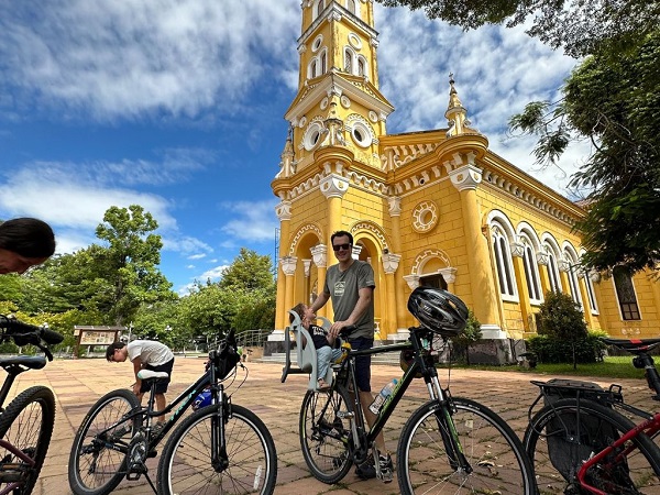 Cyclists at the unique yellow Gothic-style European temple in Bang Pa In Summer Palace grounds