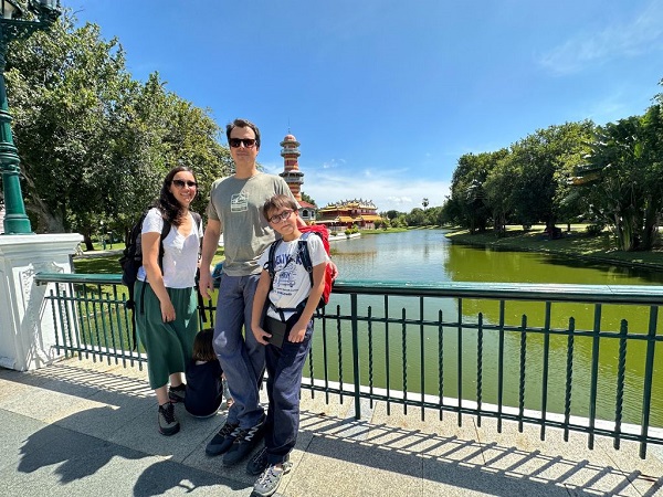 Family posing on a bridge with the scenic Bang Pa In palace lake and pagoda in the background
