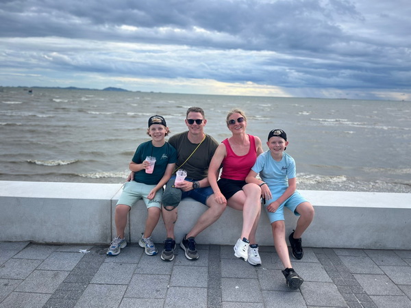 Family enjoying the ocean view at Bang Saen beach during the cycling tour