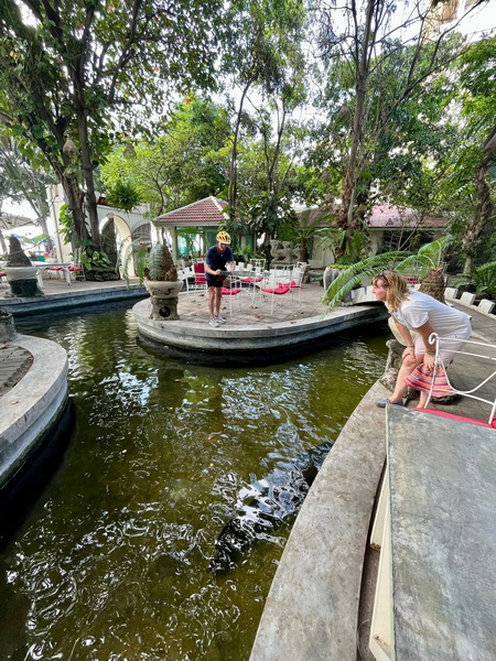 Tour guests relaxing at a beautiful garden cafe with a pond during the coffee stop