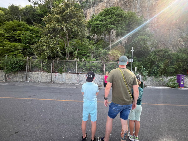 Family watching the free-roaming monkeys at Khao Sam Muk peak