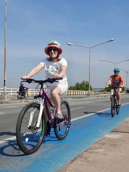Cyclists riding safely on the dedicated blue bike lane along the Bang Saen coast