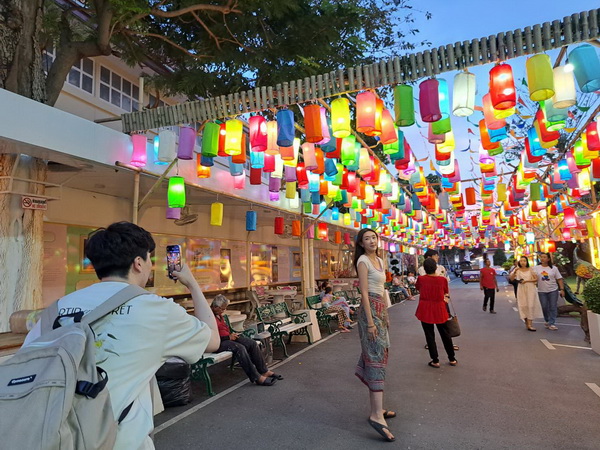 Street decorated with hundreds of colourful hanging lanterns near the Golden Mountain temple at dusk