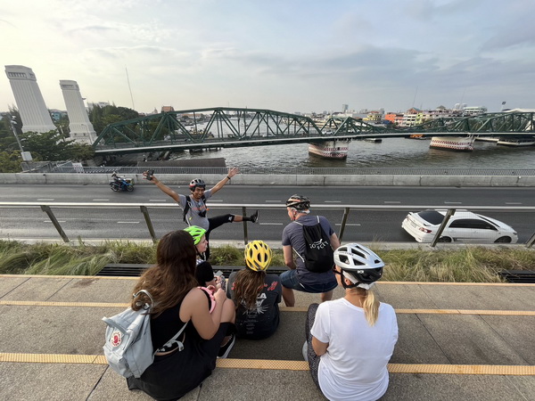 Tour guide entertaining the group with a playful pose on the Sky Bridge overlooking the Memorial Bridge