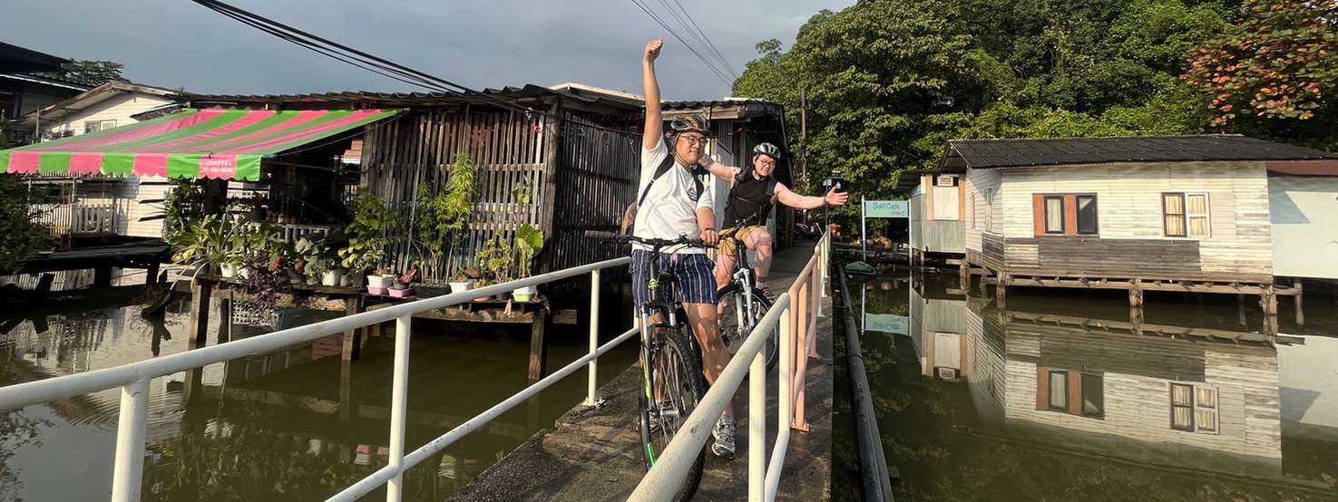 Cyclists crossing Rama 8 bridge with panoramic Chao Phraya river views on Bangkok Behind the Scenes bike tour