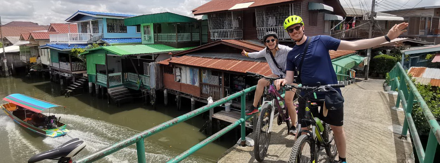 Cycling through authentic Bangkok floating markets with traditional boats and canal vendors