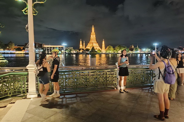 Bangkok skyline and Chao Phraya river at night viewed from Memorial Bridge during cycling tour