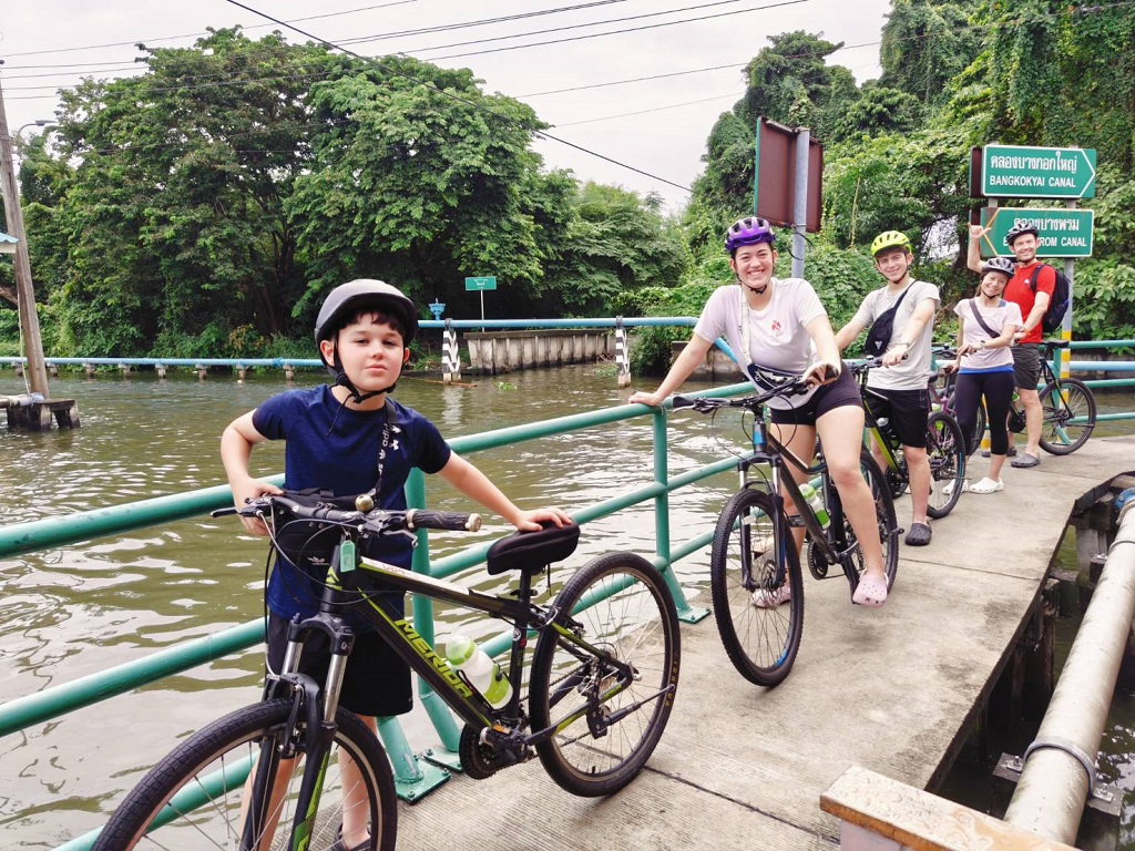 Scenic canal view at Taling Chan floating market with traditional Thai boats and vendors