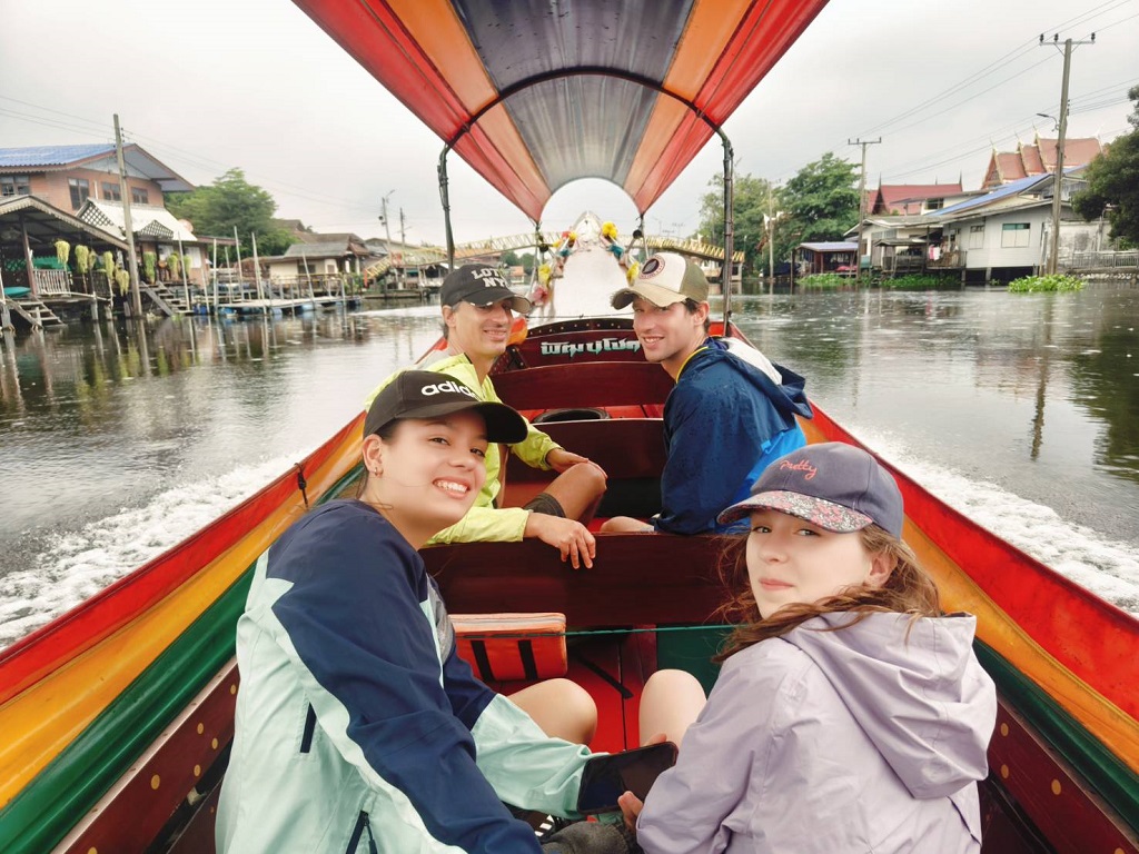 Traditional long tail boat navigating narrow Bangkok khlong canals