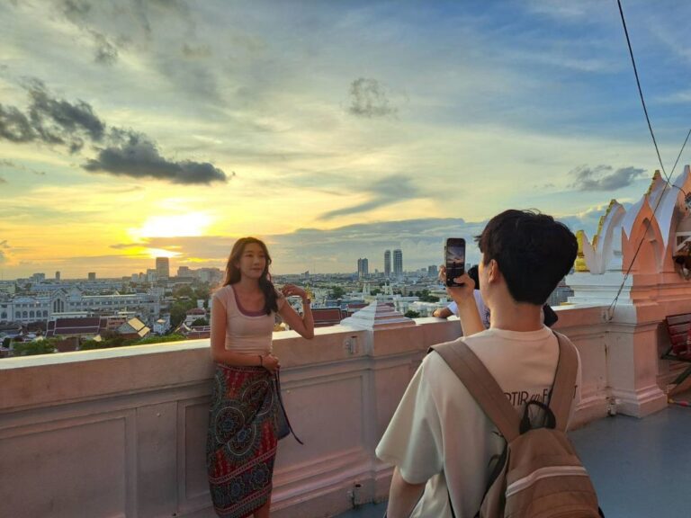 Cyclists crossing the Chao Phraya river via the modern Sky Garden bridge at dusk
