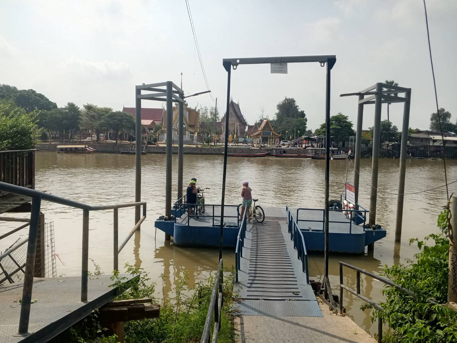 Cyclists crossing the Chao Phraya river by local ferry on the Road to Ayutthaya tour