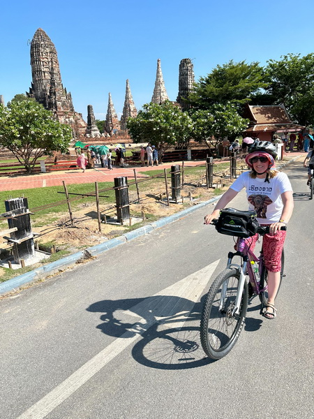 Cyclists exploring ancient temple ruins at UNESCO World Heritage Ayutthaya historical park