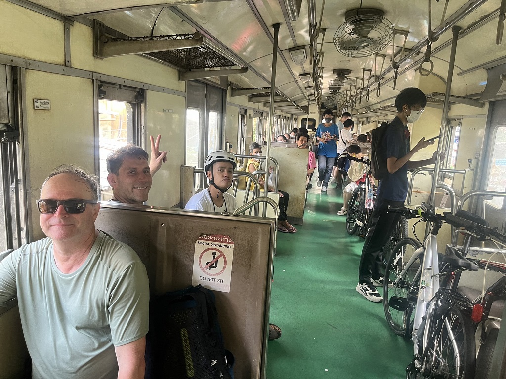 Cyclists boarding the local Thai train for the City to Shore tour journey