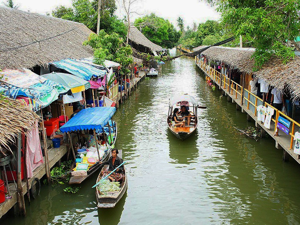Traditional wooden boats selling fresh produce and handmade goods in Bangkok floating market canals